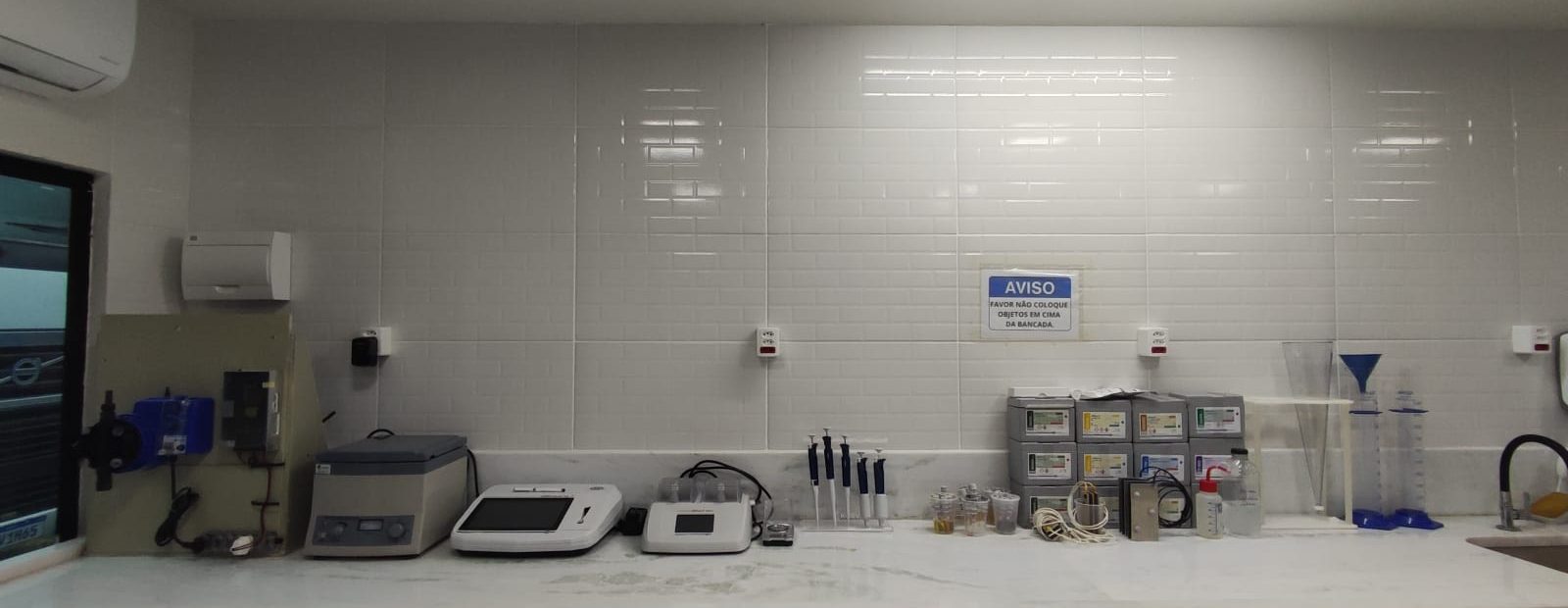 Bancada analítica com centrífuga, agitador e pipetas para controle de processo.